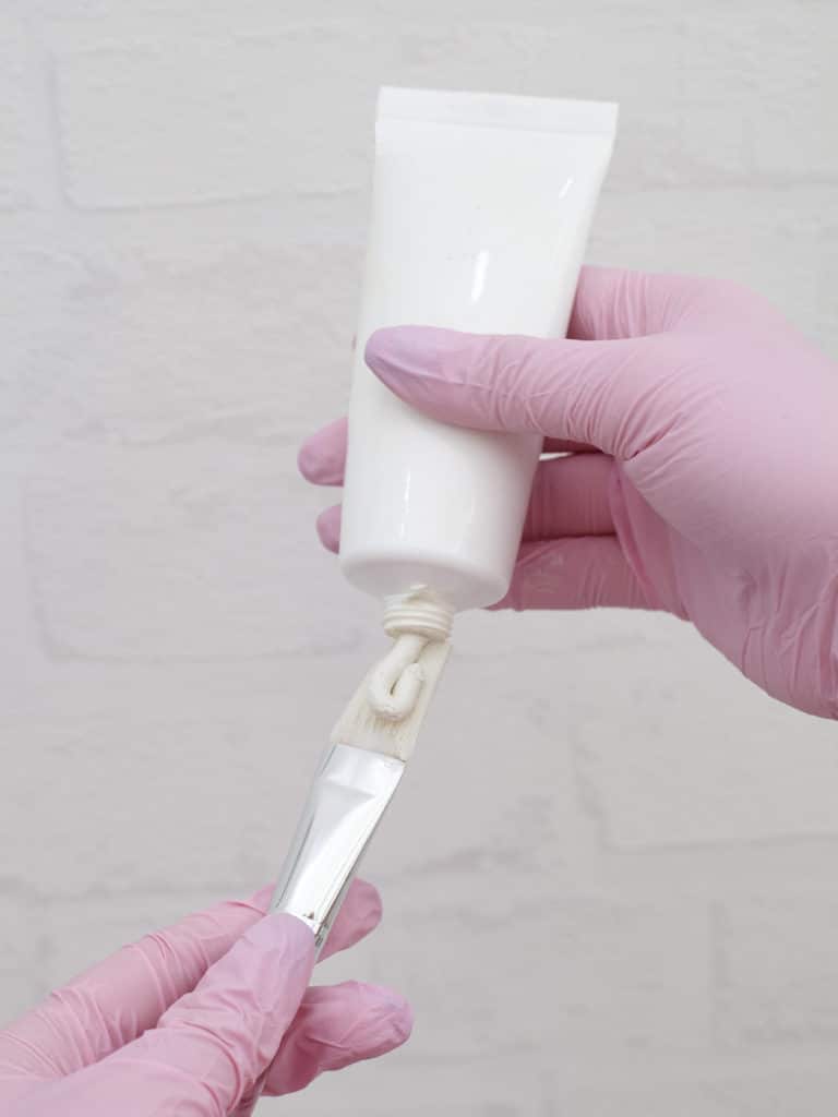 lidocaine cream for cosmetic procedures is squeezed out of the tube onto the brush